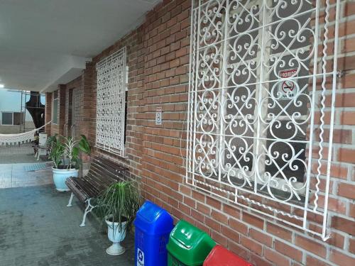 a brick wall with a bench and some plants at Pousada Solar do Lazer in Recife