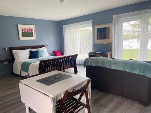ゴールウェイにあるThe Cosy Studio by the shoreの青い壁のベッドルーム1室、ベッド1台、テーブルが備わります。