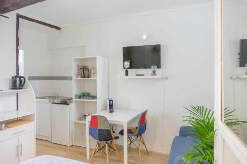 une petite cuisine blanche avec une table et des chaises dans l'établissement Studio Rue piétonne Orléans, à Orléans