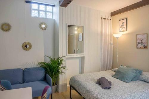 オルレアンにあるStudio Rue piétonne Orléansのベッドと青いソファのある寝室