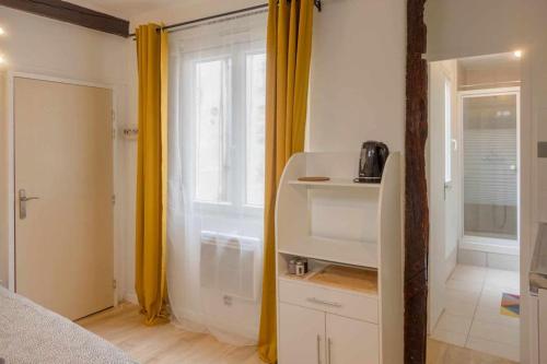 オルレアンにあるStudio Rue piétonne Orléansの窓と黄色いカーテンのある寝室のある部屋
