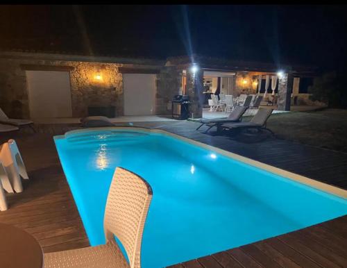 uma grande piscina com iluminação azul num quintal em Villa Pierre SANTONI em Porticcio