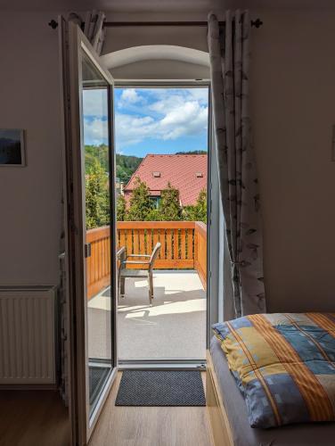 a bedroom with a door open to a balcony at Ferienwohnungen Langer in Stadt Wehlen