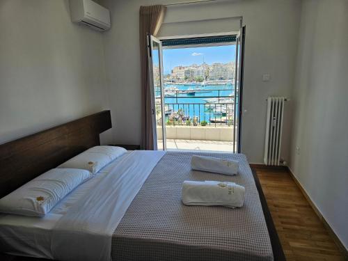 um quarto com uma cama grande e uma janela grande em Piraeus center sea view apartment em Piraeus