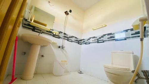 a bathroom with a toilet and a sink at Vantage Lodge in Skardu