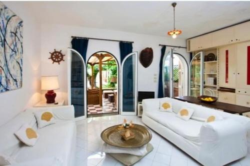 ein Wohnzimmer mit einem weißen Sofa und einem Tisch in der Unterkunft Villa Sofia in Massa Lubrense