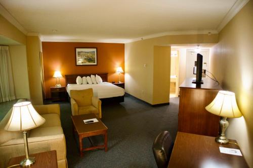 une chambre d'hôtel avec un lit et un canapé dans l'établissement Hotel Mead Resorts & Conventions Center, à Wisconsin Rapids