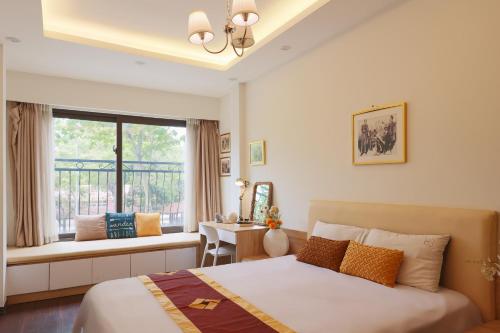ハノイにあるcozyfun homestay Lê Hồng Phongのベッドルーム1室(ベッド1台、窓、デスク付)