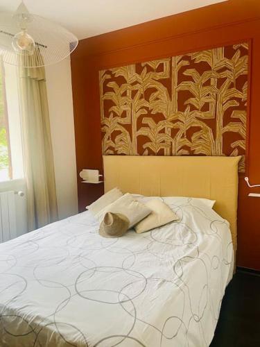 un lit avec deux oreillers et une tête de lit avec un mur dans l'établissement Krystel Avel à La baule, à La Baule