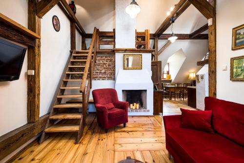 a living room with a staircase and a fireplace at Apartamenty Kamienica Muzyków Old Town Lublin in Lublin