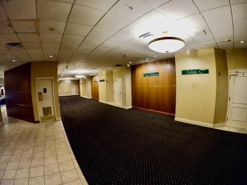 an empty hallway in a office building with a hallway at Hotel Mead Resorts & Conventions Center in Wisconsin Rapids