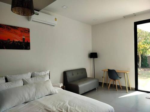 1 dormitorio con 1 cama, 1 silla y 1 mesa en BRAND-NEW! The Private PoolVilla /4BR byน้องมังคุด, en Nong Prue