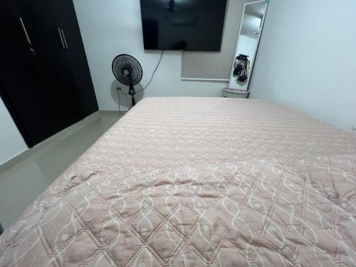 a large bed in a room with a fan at Apartamento festival vallenato in Valledupar