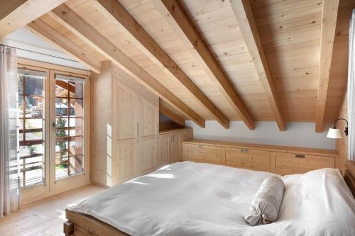 a bedroom with a large bed and a wooden ceiling at Chalet Cinq Moutons in Orsières