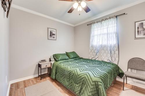 a bedroom with a green bed and a window at Baton Rouge Home with Yard about 14 Mi to Downtown! in Baton Rouge