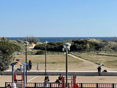 a park with people walking and a playground at Casa Ermes - Piano terra indipendente fronte spiaggia, ampio spazio esterno attrezzato in Marina di Pescoluse