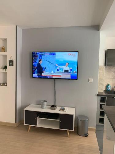un salon avec une télévision à écran plat sur un mur dans l'établissement Studio - Centre ville Ajaccio, à Ajaccio