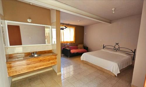 HOTEL XANTI في موريليا: غرفة نوم بسرير وحمام مع حوض