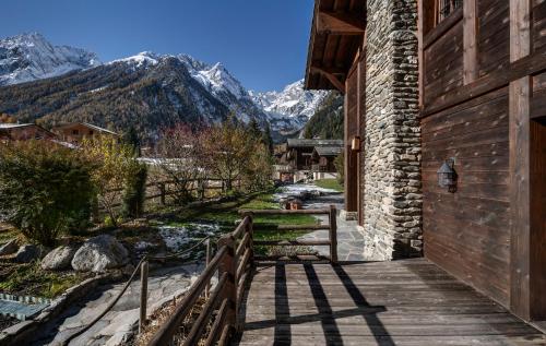 a wooden walkway leading to a building with mountains in the background at Chalet Cinq Moutons in Orsières