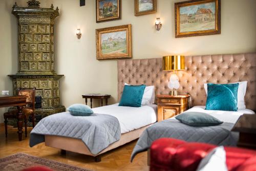 a bedroom with two beds with blue pillows at Apartamenty Kamienica Muzyków Old Town Lublin in Lublin