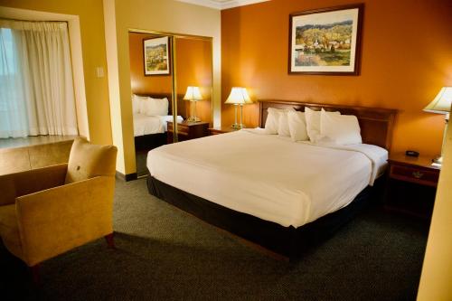 a hotel room with a large bed and a chair at Hotel Mead Resorts & Conventions Center in Wisconsin Rapids