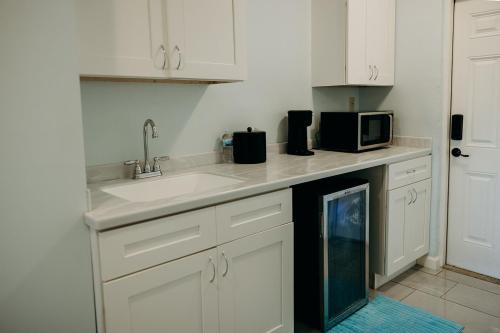 a kitchen with a sink and a microwave at Grapetree Bay Hotel and Villas in Christiansted