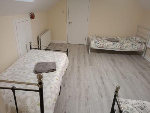 a bedroom with two beds and a wooden floor at Dublin Palm 2 Shared rooms in Dublin