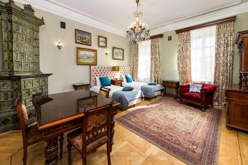 a living room with a piano and a bed and a desk at Apartamenty Kamienica Muzyków Old Town Lublin in Lublin