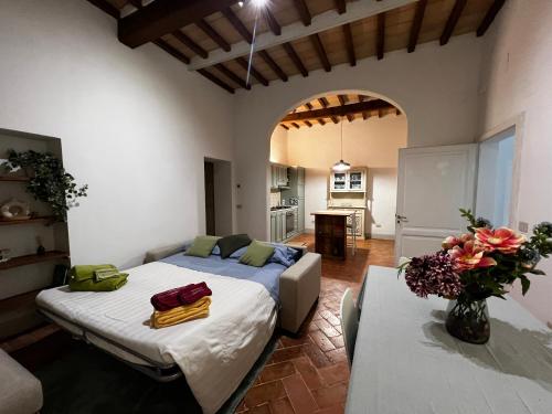 Un dormitorio con 2 camas y una mesa en una habitación en Casa ROMA21, en Buonconvento