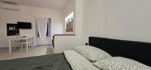 a bedroom with a bed and a living room with a table at The white cave- Bluchalet in Riomaggiore