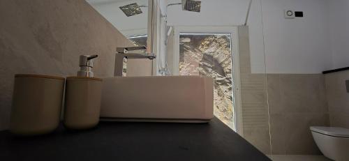 a bathroom counter with a sink and a window at The white cave- Bluchalet in Riomaggiore