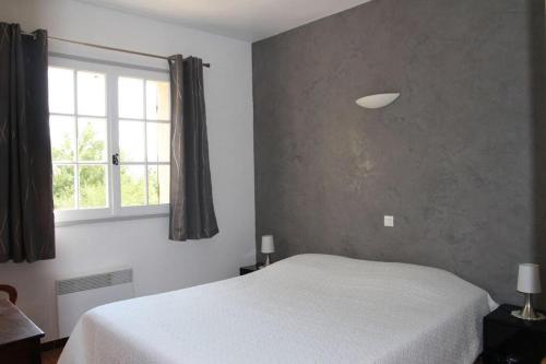 une chambre avec un lit blanc et une fenêtre dans l'établissement Villa LA PIBOULE, à Bagnols-en-Forêt