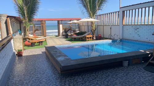una piscina junto a una casa con playa en Mazama Casa de playa, en Bocapán