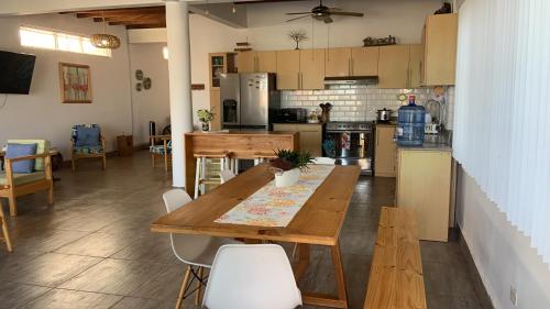 Bocapán的住宿－Mazama Casa de playa，厨房以及带木桌和椅子的用餐室。