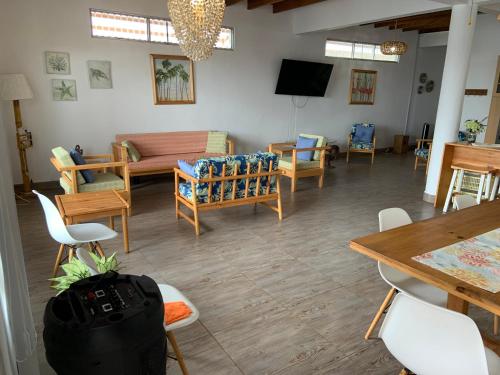 sala de estar con sofá, mesas y sillas en Mazama Casa de playa, en Bocapán