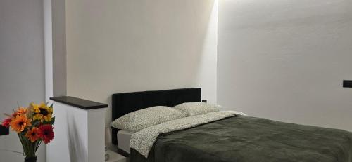 a bedroom with a bed and a vase with flowers at The white cave- Bluchalet in Riomaggiore