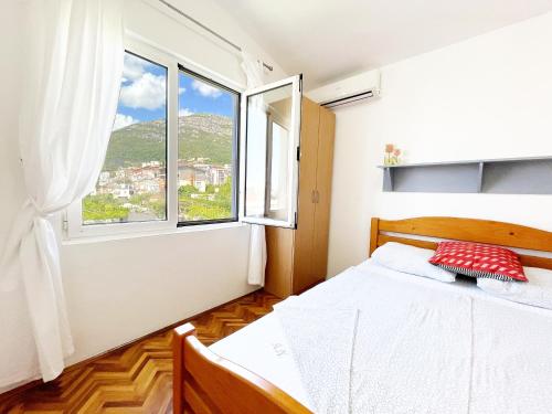 sypialnia z łóżkiem i oknem w obiekcie Apartmani Novkovic w Barze