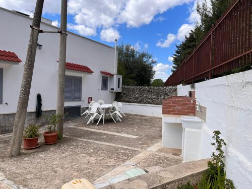 um pátio com uma mesa e cadeiras num quintal em A casa di nonna Lina em Polignano a Mare