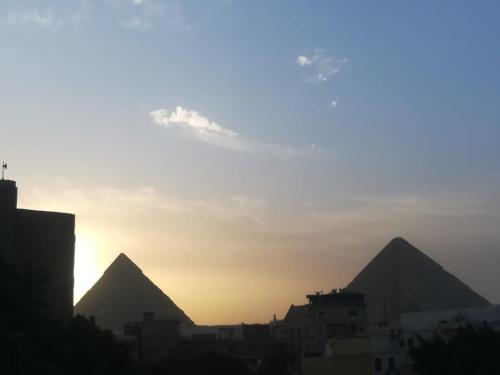 a view of the pyramids of giza at sunset at Nana Pyramids Guest House in Cairo