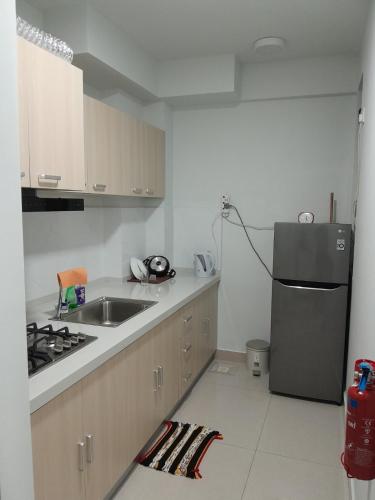 a kitchen with a sink and a refrigerator at Cozy One-Room Apartment Stay in Hulhumale