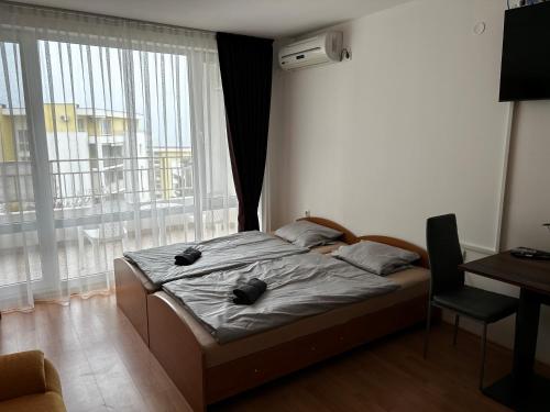 a bedroom with a bed and a large window at Peter Apartmanbulgaria-Imperial Fort Noks in Elenite