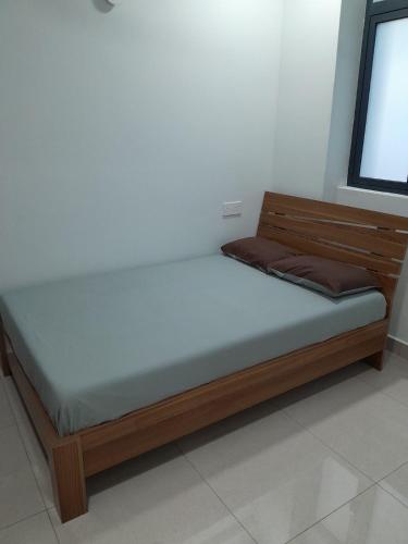 a bed with a wooden frame in a room at Cozy One-Room Apartment Stay in Hulhumale
