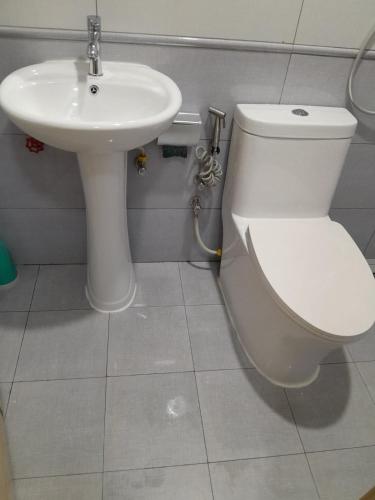a bathroom with a toilet and a sink at Cozy One-Room Apartment Stay in Hulhumale