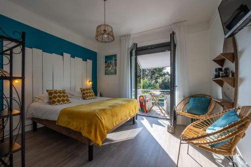 ein Schlafzimmer mit einem Bett und einem Stuhl in der Unterkunft Hotel La Roseraie in Fouras