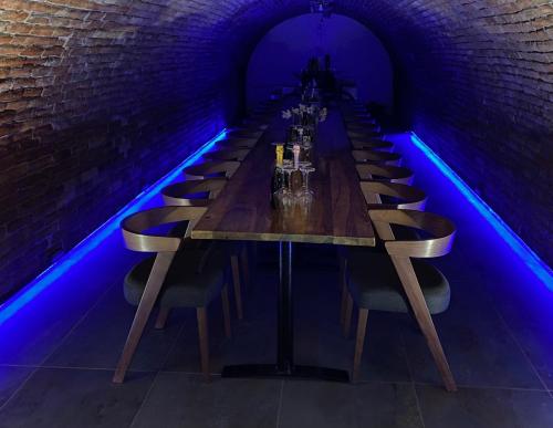 a long table in a dark room with blue lights at Studio apartman & Wine House ONDINE in Zmajevac