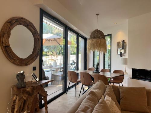 a living room with a couch and a table with a mirror at Superbe Villa très proche cannes in Mougins