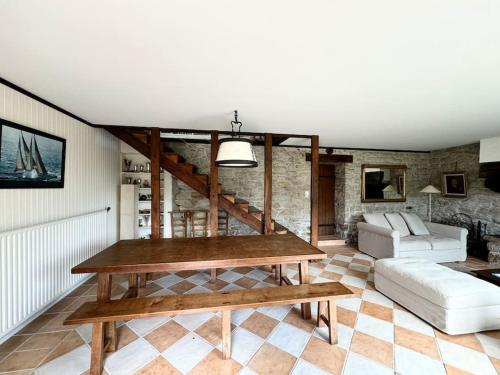 a living room with a table and a couch at La Ferme, spacieuse maison tout confort, Bénodet in Bénodet