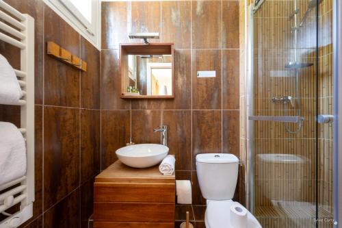 a bathroom with a sink and a toilet and a shower at Hotel La Roseraie in Fouras