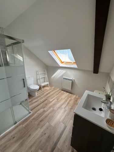 a bathroom with a shower and a sink and a skylight at Casa Bieiteiros in Valdoviño