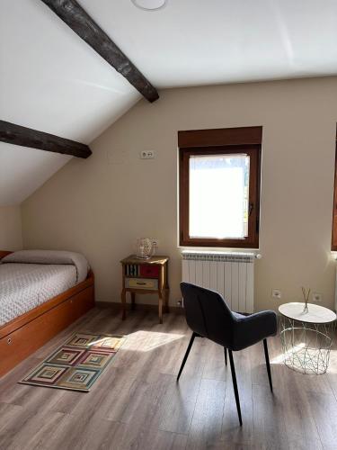 a bedroom with a bed and a chair and a table at Casa Bieiteiros in Valdoviño